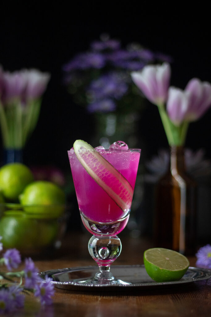 a pink cocktail with ribbon of cucumber ribbon.