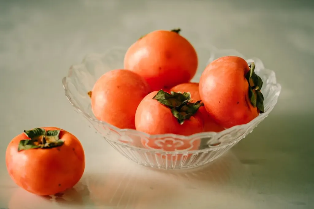Persimmons in a glass bowl
