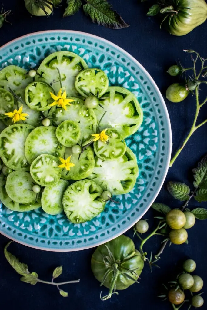 Sliced green tomatoes on a blue plate