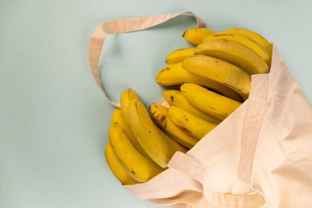 Bundles of fresh bananas in eco friendly bag
