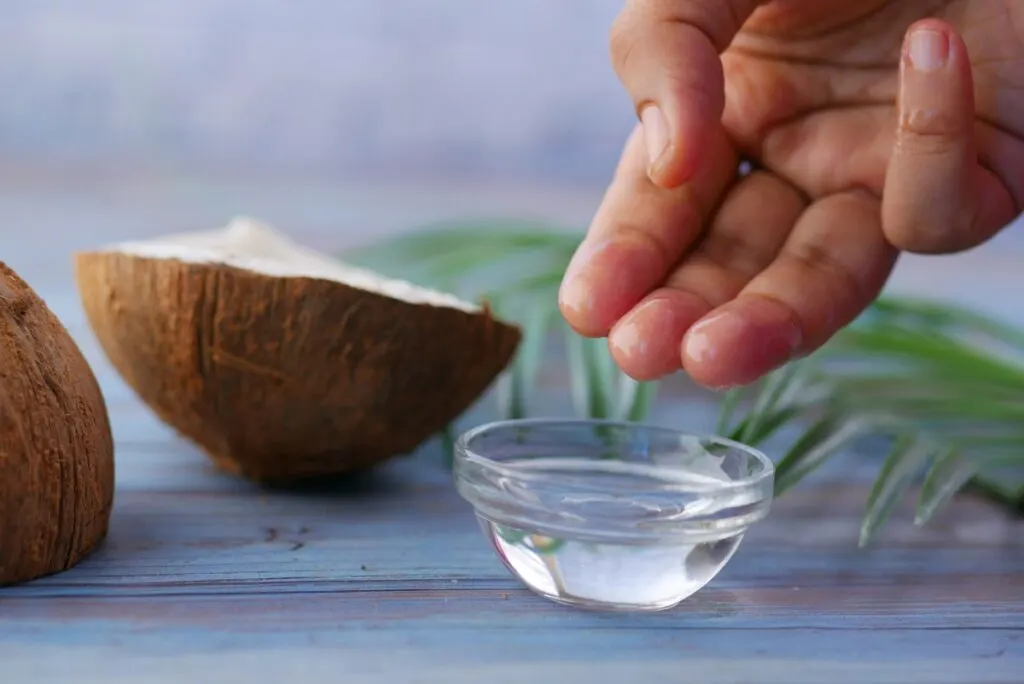 Clear glass bowl with white liquid and coconut in the background